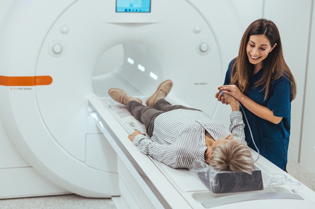 Patientin bei einer MRT-Untersuchung, wobei der Techniker ihr Sicherheit und Unterstützung vermittelt